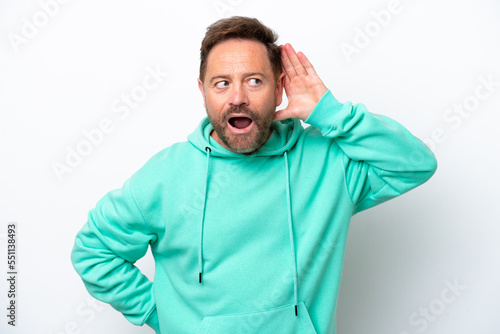 Middle age caucasian man isolated on white background listening to something by putting hand on the ear © luismolinero