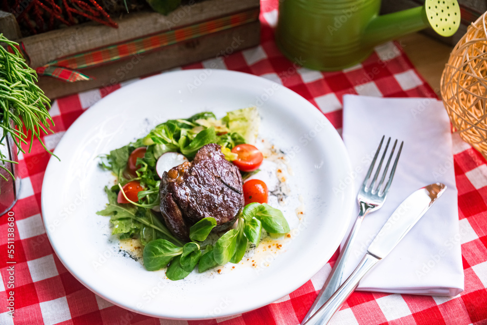 Beef steak chateaubriand with corn salad and arugula leaves, cherry tomato slices, olive oil Beef steak chateaubriand with corn salad and arugula leaves, cherry tomato slices, olive oil
