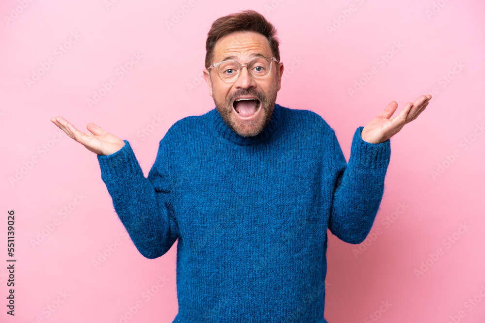 Middle age caucasian man isolated on pink background with shocked facial expression Middle age caucasian man isolated on pink background with shocked facial expression