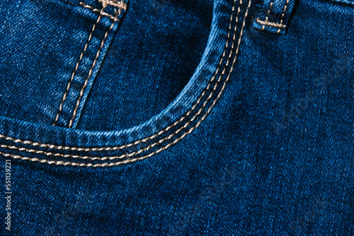 Stylish denim background. Close-up of the fabric of blue women's jeans