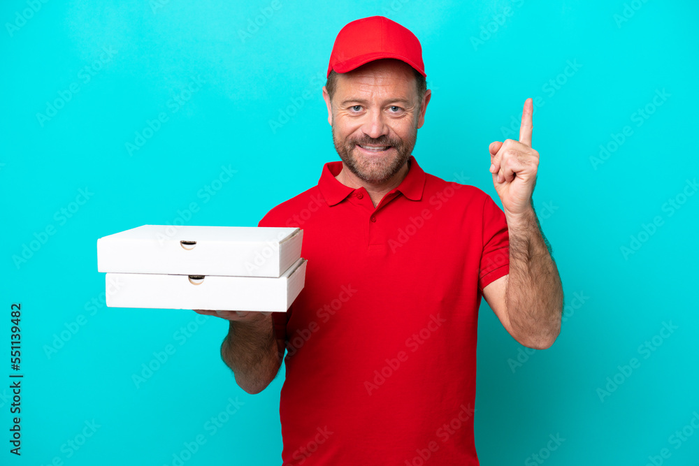 Pizza delivery man with work uniform picking up pizza boxes isolated on blue background showing and lifting a finger in sign of the best Pizza delivery man with work uniform picking up pizza boxes isolated on blue background showing and lifting a finger in sign of the best