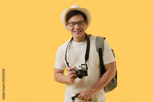 Portrait Asian young man wearing hat and holding camera and travel bag smiling to camera.