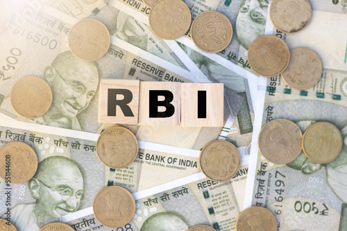 RBI text on wooden cube on Indian currency and coins photo