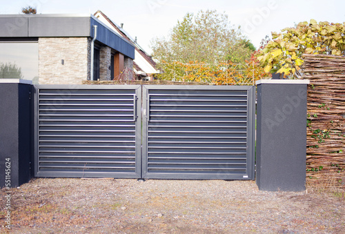 Closed modern grey gate that protect a property