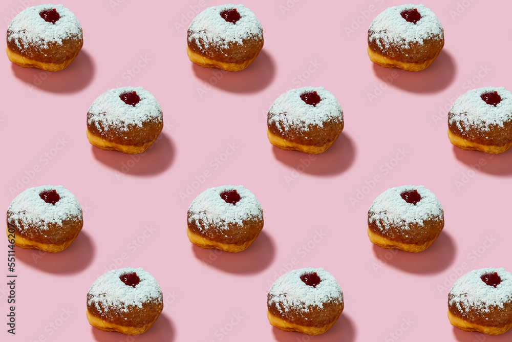 Jewish holiday Hanukkah concept. Pattern with donut sufganiyot on a pink background. Jewish holiday Hanukkah concept. Pattern with donut sufganiyot on a pink background.