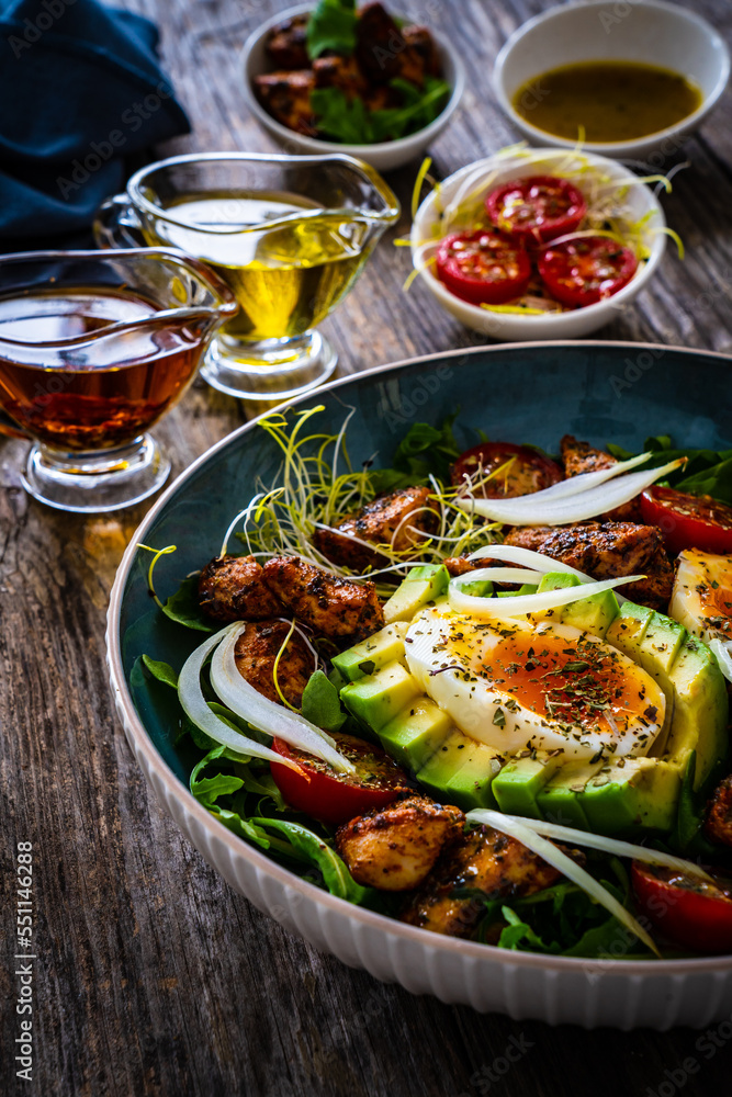 Tasty salad - fried chicken breast, avocado, boiled eggs, mini tomatoes and fresh green vegetables on wooden background
Tasty salad - fried chicken breast, avocado, boiled eggs, mini tomatoes and fresh green vegetables on wooden background