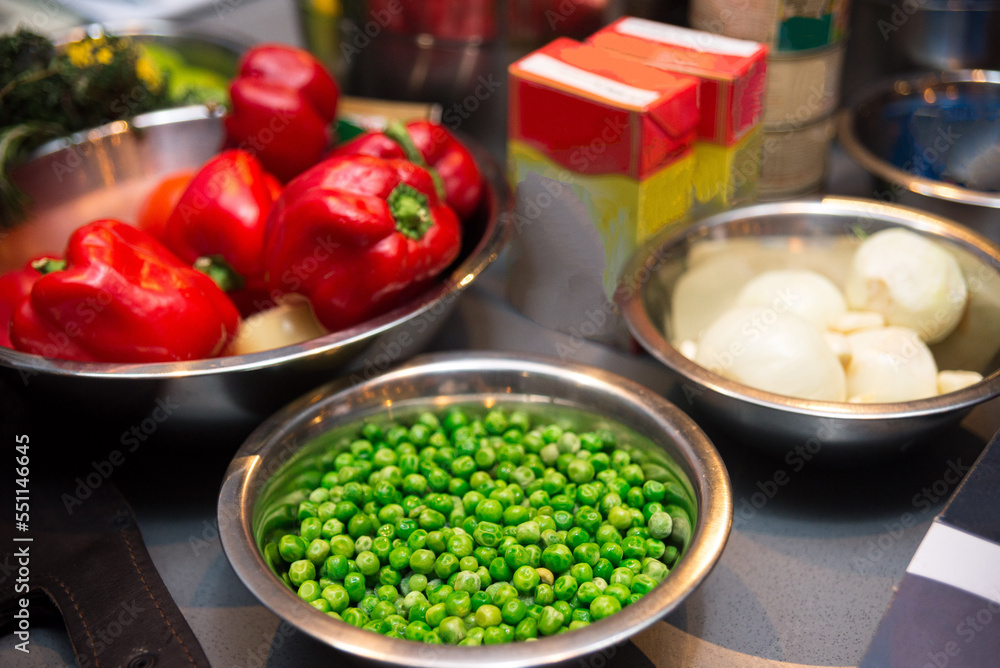 A set of raw food ingredients before making dinner. Fresh green peas, ripe red bell peppers, onions. A set of raw food ingredients before making dinner. Fresh green peas, ripe red bell peppers, onions.