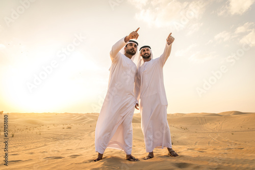 Arab men wearing typical middle eastern clothing in the desert