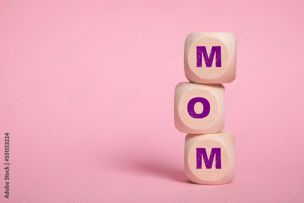 MOM acronym letters on wooden blocks isolated on light pink background copy space MOM acronym letters on wooden blocks isolated on light pink background copy space
