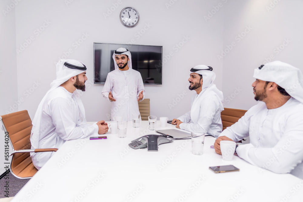 Group of businessmen wearing traditional emirates kandora in Dubai working in the office 