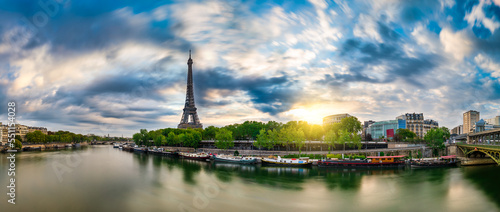 Eiffel Tower by seine river at sunrise in Paris. France
