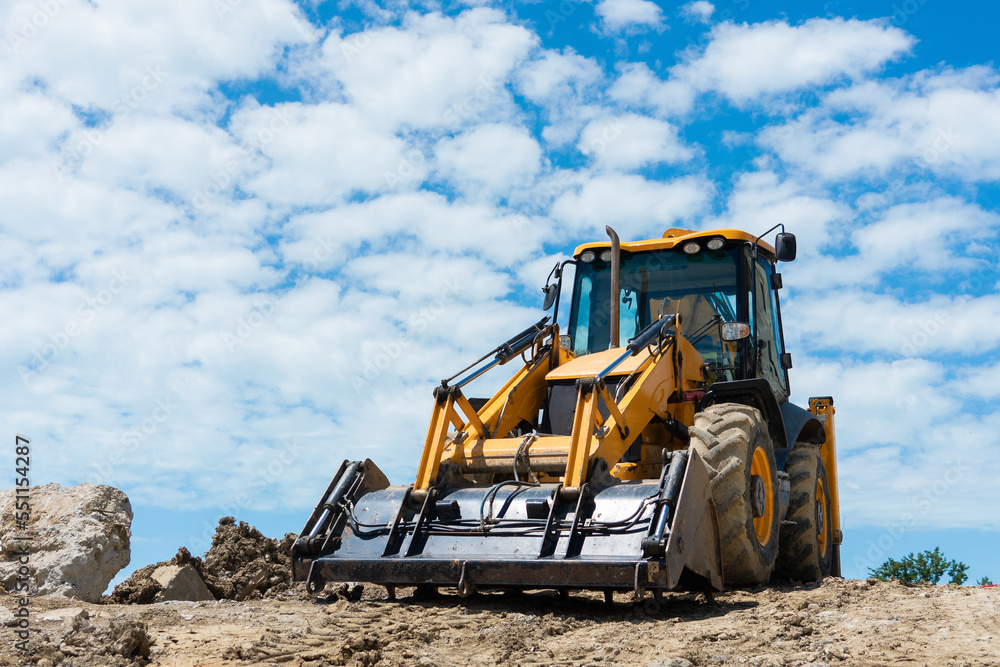 Big yellow excavator. Excavator on the background of the sky with clouds. Excavator at the construction site. Big yellow excavator. Excavator on the background of the sky with clouds. Excavator at the construction site.