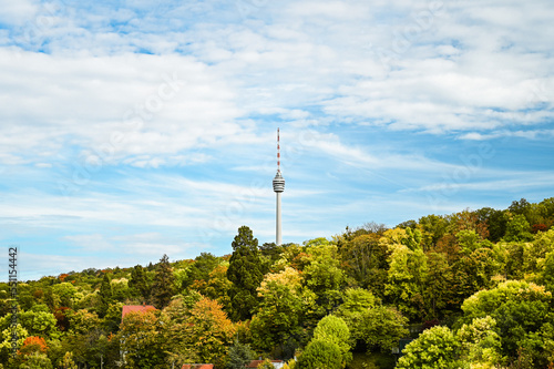 Autumnal view of the Stuttgart TV tower under a partly cloudy sky. The TV tower is surrounded by colorful forest. photo