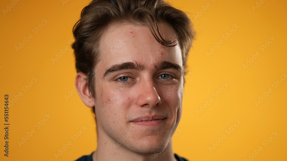 Closeup portrait of smiling happy young hipster man 20s isolated on solid yellow background with copy space in studio Closeup portrait of smiling happy young hipster man 20s isolated on solid yellow background with copy space in studio