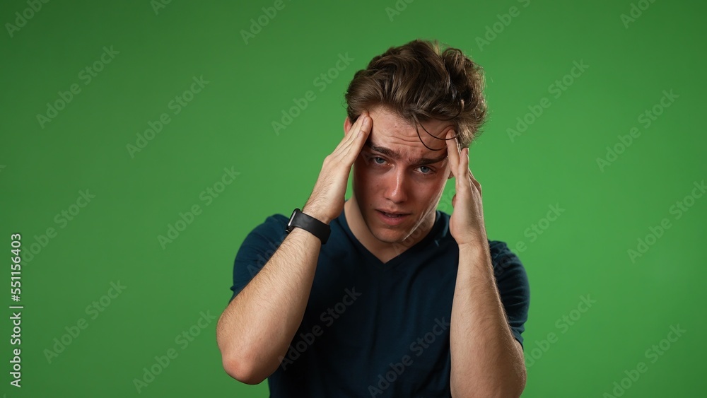 portrait of sick tired headache migraine exhausted displeased young man 20s posing isolated on green screen background studio. Put hands on head portrait of sick tired headache migraine exhausted displeased young man 20s posing isolated on green screen background studio. Put hands on head