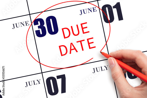 Hand writing text DUE DATE on calendar date June 30 and circling it. Payment due date