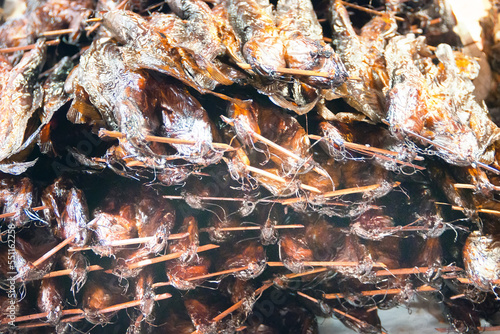 Thai cuisine. Grilled smoked fish (catfish - catfish moustache like ropes) tied in bundles for sale photo