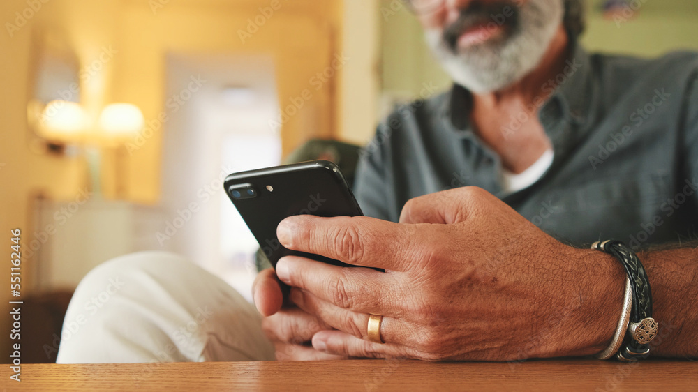 Close-up of an elderly man's hands typing on mobile phone sitting in the kitchen Close-up of an elderly man's hands typing on mobile phone sitting in the kitchen