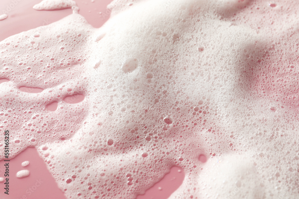 Fototapeta premium White washing foam on pale pink background, top view