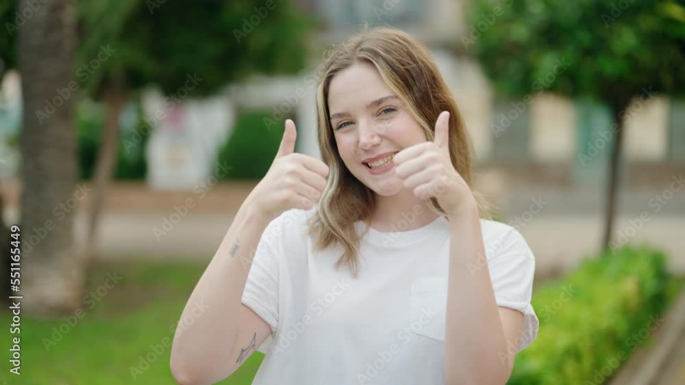 Young caucasian woman smiling confident doing ok sign with thumbs up at park Young caucasian woman smiling confident doing ok sign with thumbs up at park