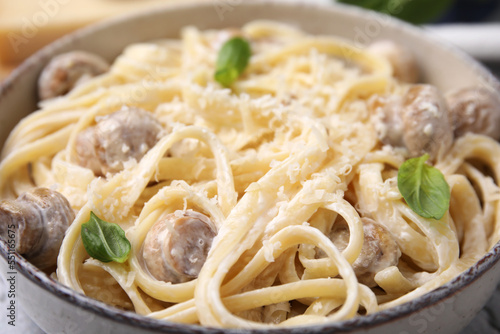 Delicious pasta with mushrooms and cheese in bowl, closeup