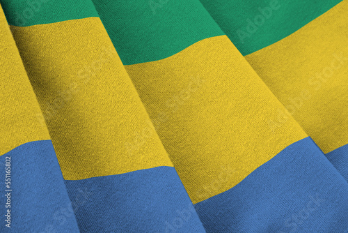 Gabon flag with big folds waving close up under the studio light indoors. The official symbols and colors in fabric banner photo