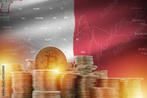 Malta flag and big amount of golden bitcoin coins and trading platform chart. Crypto currency concept photo