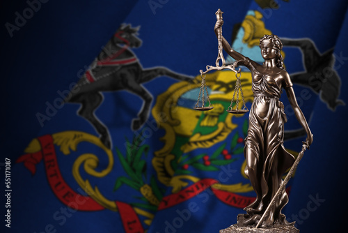 Pennsylvania US state flag with statue of lady justice and judicial scales in dark room. Concept of judgement and punishment, background for jury topics photo
