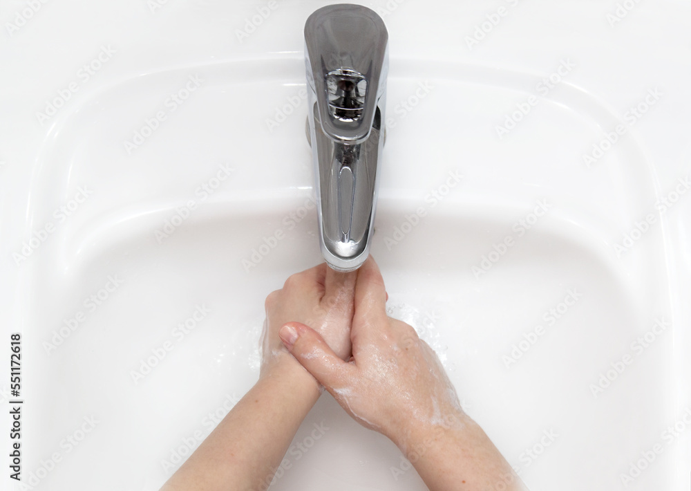 Woman use soap and washing hands under the water tap. Hygiene concept ...