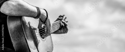 Acoustic guitars playing. Music concept. Black and white. Male musician playing guitar, music instrument. Man's hands playing acoustic guitar, close up