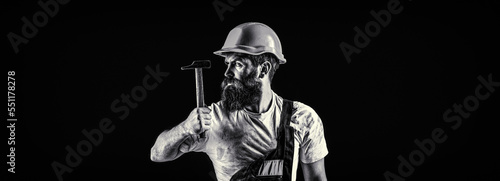 Fototapeta Naklejka Na Ścianę i Meble -  Bearded man worker with beard, building helmet, hard hat. Hammer hammering. Builder in helmet, hammer, handyman, builders in hardhat. Black and white