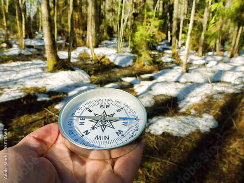 Tourism and orientation in the winter forest. A snow-covered pine forest and a compass in the hiker's hand photo