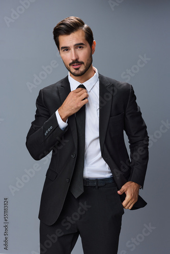Handsome male model in business suit young businessman smiling kind look on gray background with tie