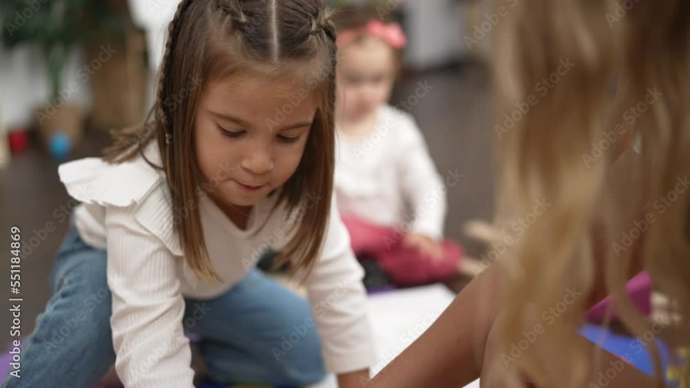 Two little girls drawing on notebook sitting on floor at kindergarten Two little girls drawing on notebook sitting on floor at kindergarten