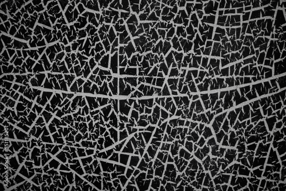 Abstract pattern of bright cracks on a black painted metal surface seems like lots of white spikes Abstract pattern of bright cracks on a black painted metal surface seems like lots of white spikes