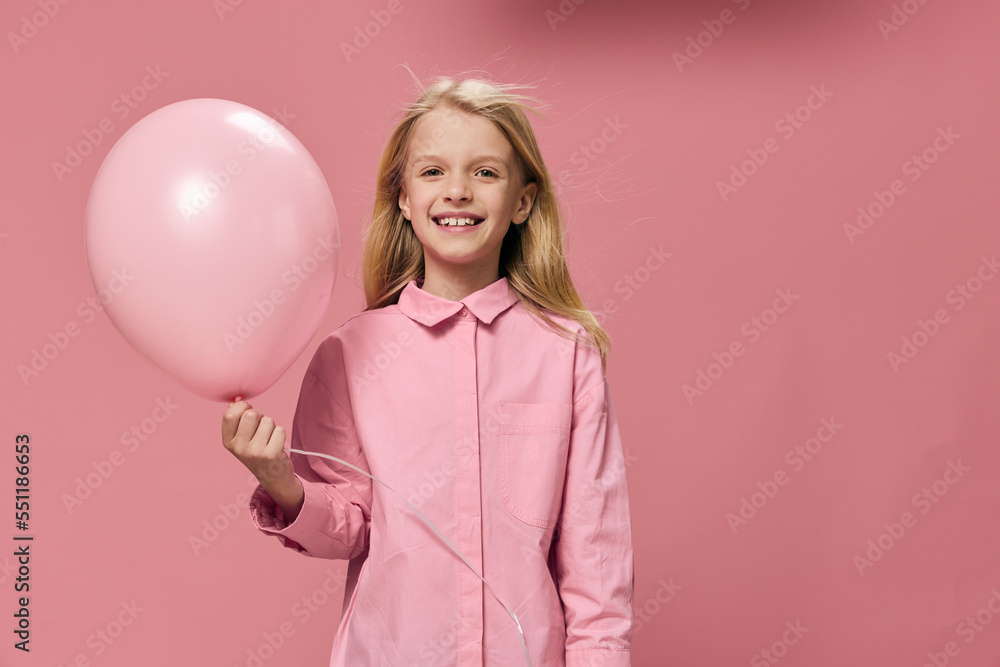 horizontal portrait of a cute beautiful, happy girl with a pink balloon in a pink dress on a pink background with an empty space for an advertising tex horizontal portrait of a cute beautiful, happy girl with a pink balloon in a pink dress on a pink background with an empty space for an advertising tex