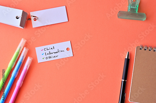 There is word card with the word chief information officer on the desk.