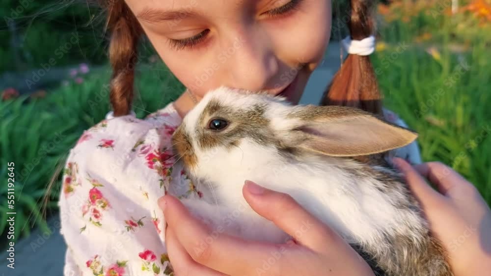 Little cute girl holding a baby rabbit outdoors Little cute girl holding a baby rabbit outdoors
