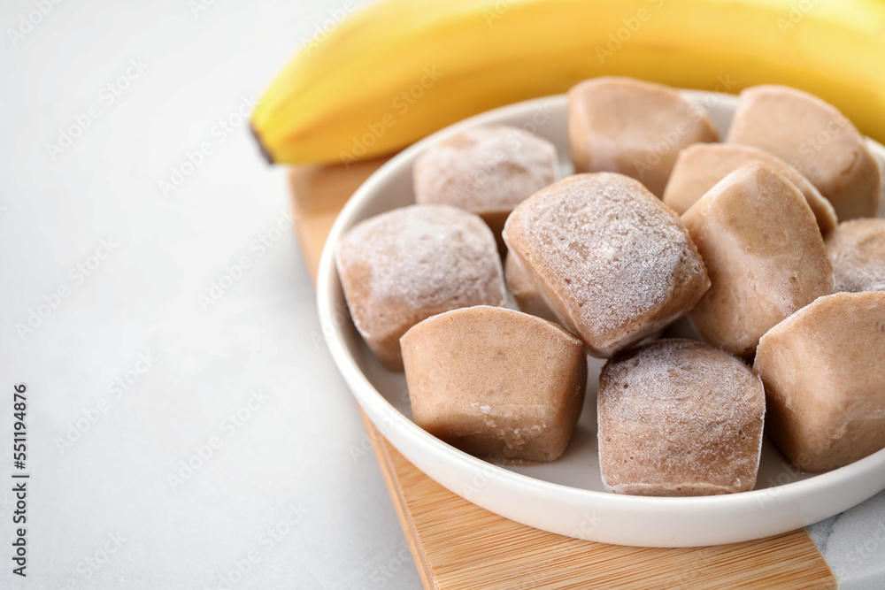 Frozen banana puree cubes and ingredient on light grey table, closeup. Space for text Frozen banana puree cubes and ingredient on light grey table, closeup. Space for text