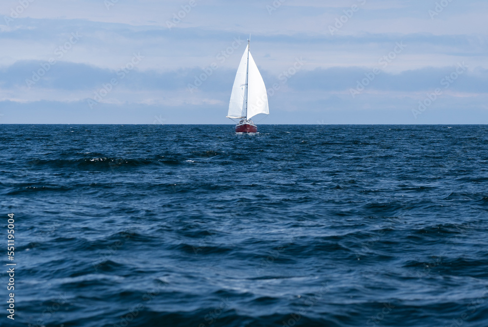 Sailing boat on blue open sea