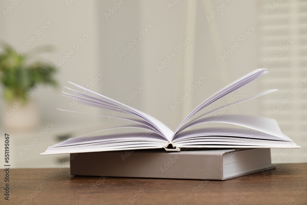 Stack of hardcover books on wooden table indoors Stack of hardcover books on wooden table indoors