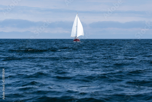 Sailing boat on blue open sea