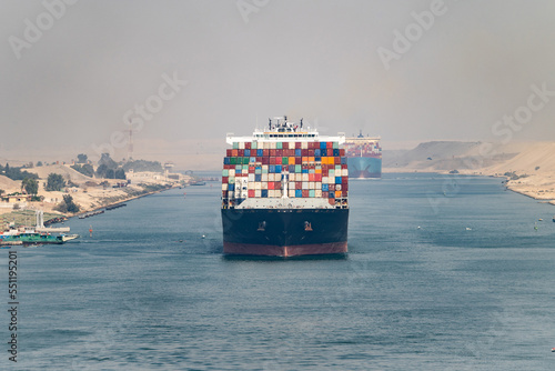 Huge cargo ships navigate through Suez Canal. Shipping canal in Egypt. Concept of transportation and logistics 
