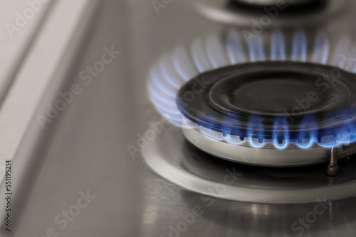 Gas burner with burning flame on cooktop, closeup © New Africa
