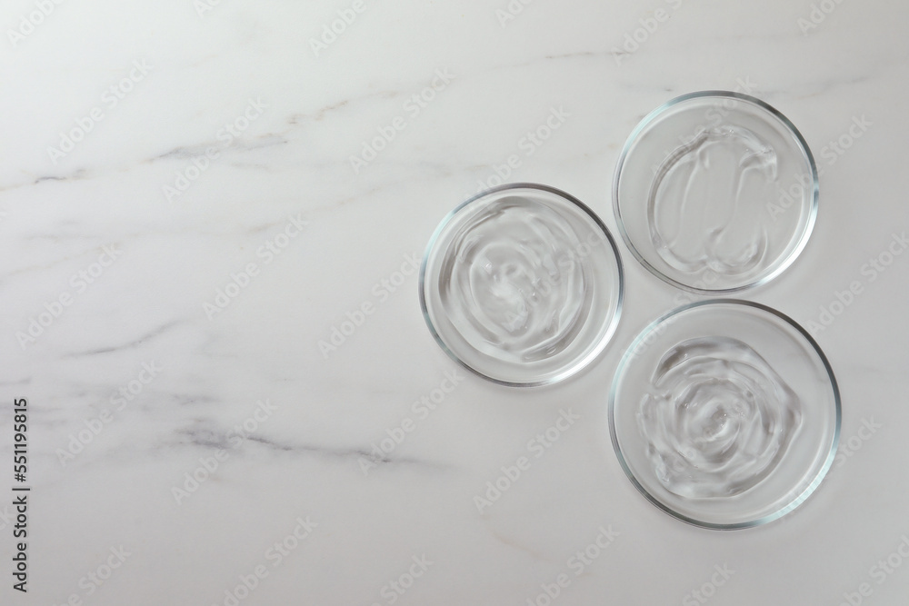 Petri dishes with liquids on white marble table, flat lay. Space for text Petri dishes with liquids on white marble table, flat lay. Space for text