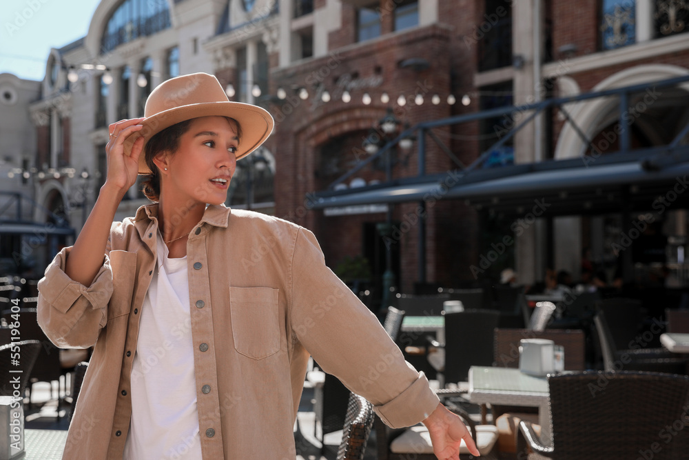 Fototapeta premium Portrait of happy young woman on city street
