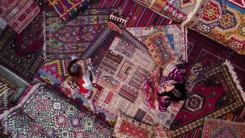 Two girls spinning on national carpets of Turkey in Cappadocia