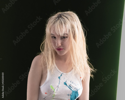Fotografia Young LA citizen in designer tank top and short plaid skirt poses in studio in a casual way