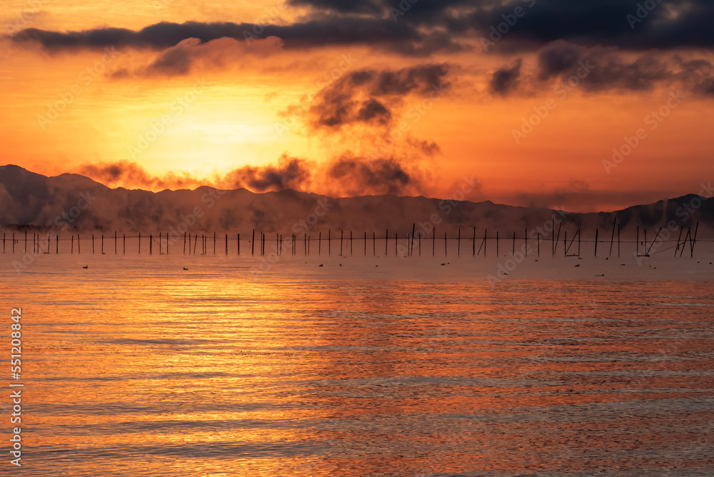 Obraz premium 琵琶湖の夜明け 冬を告げる大きな気嵐 幻想的な朝焼けの風景 滋賀県大津市 湖西の和邇浜