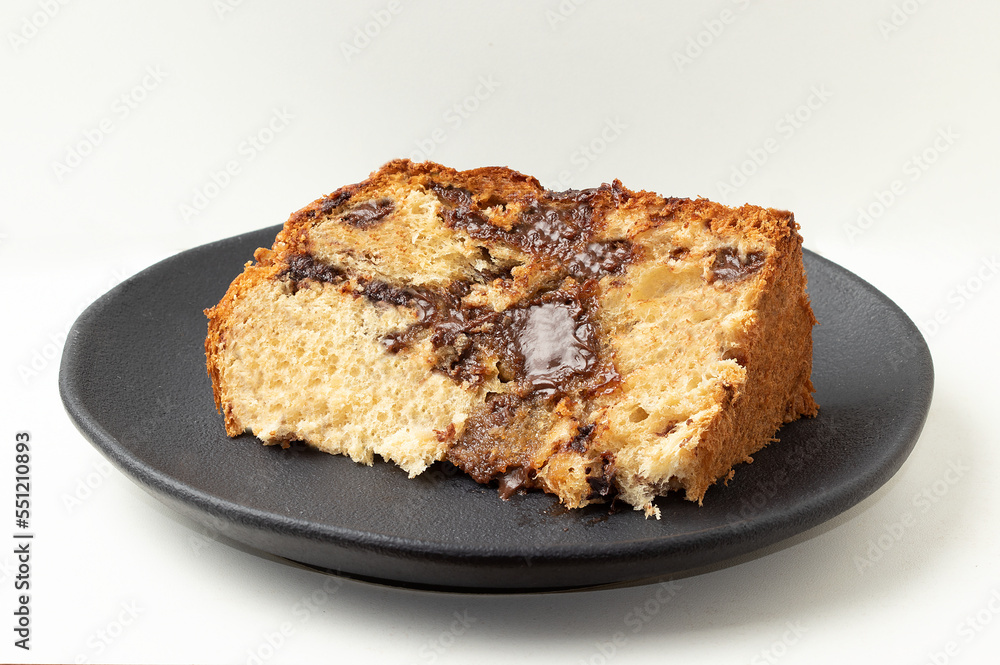 Sliced panettone stuffed with chocolate on plate.